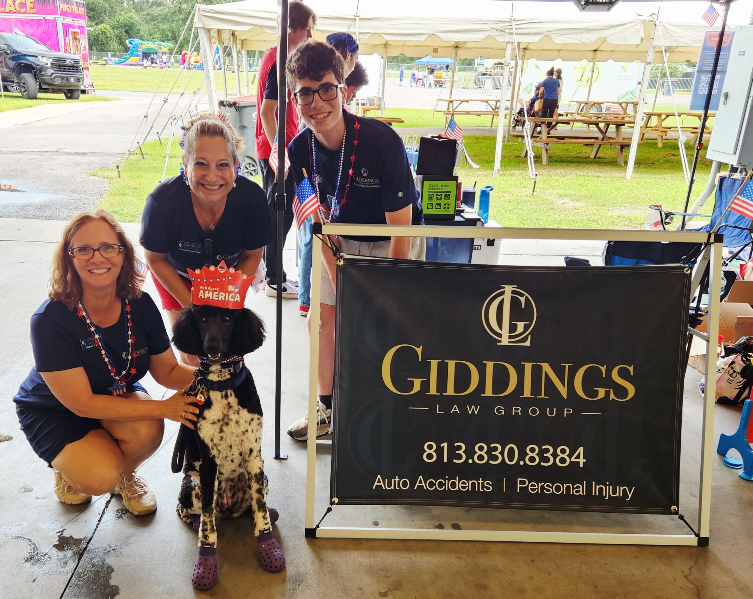The Giddings Law Group Team at the Hillsborough County Fair Grounds pictured next to a dog named Willow.