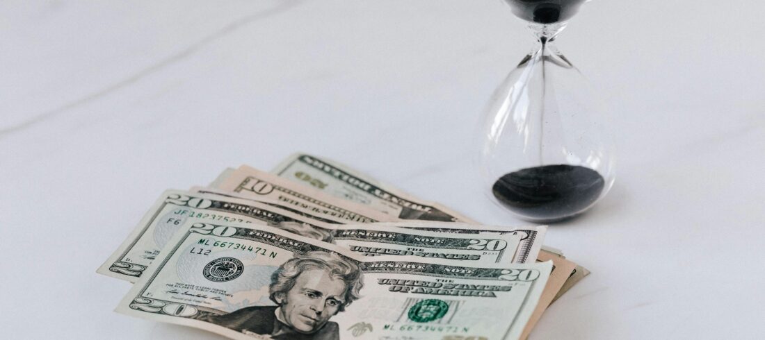 Hourglass near Heap of American Dollars